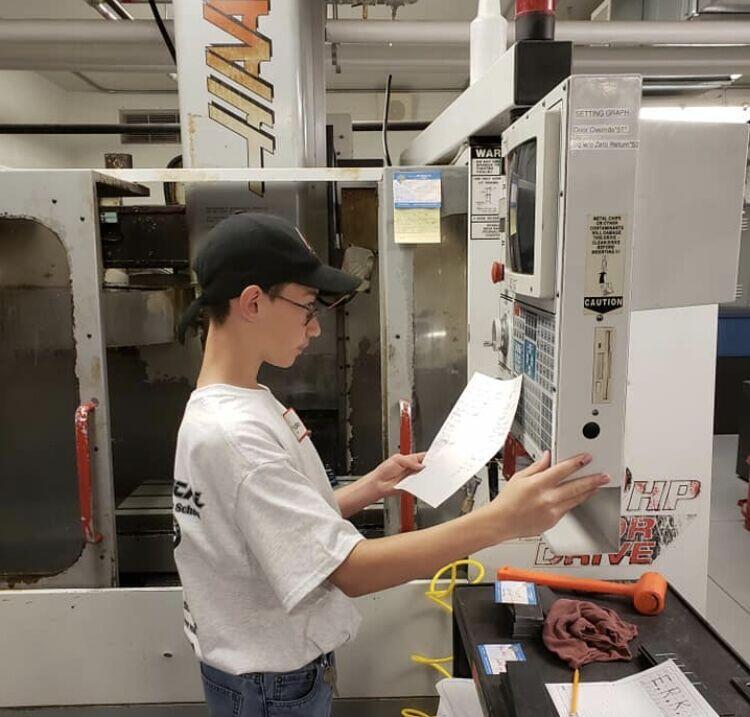Student coding a CNC Machine.